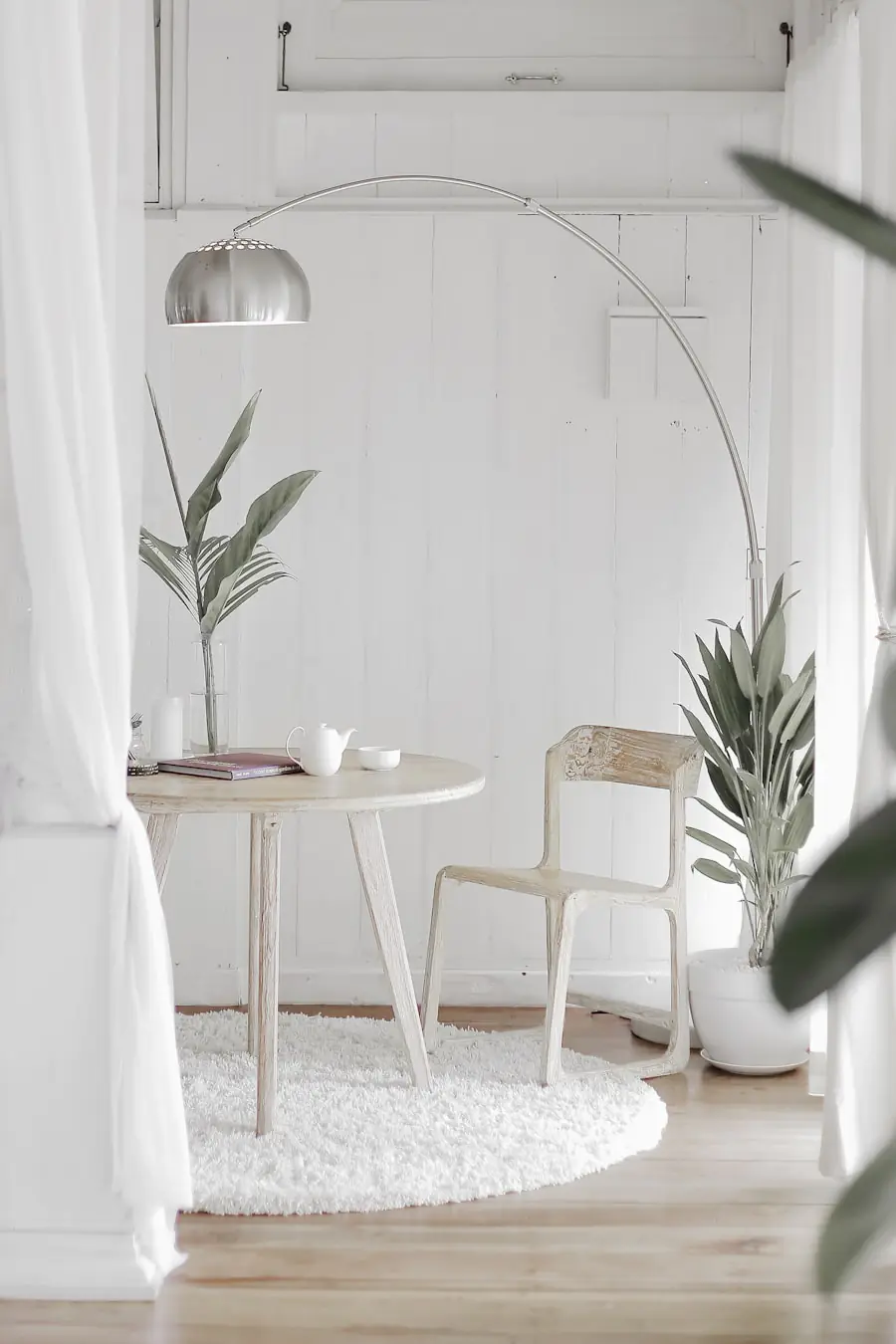 Person sitting thoughtfully among personal possessions, holding an object and considering whether to keep or release it — the deliberate evaluation process at the heart of Swedish death cleaning